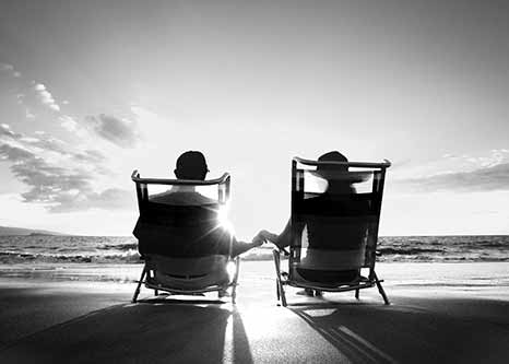 black and white photo of two people on the beach