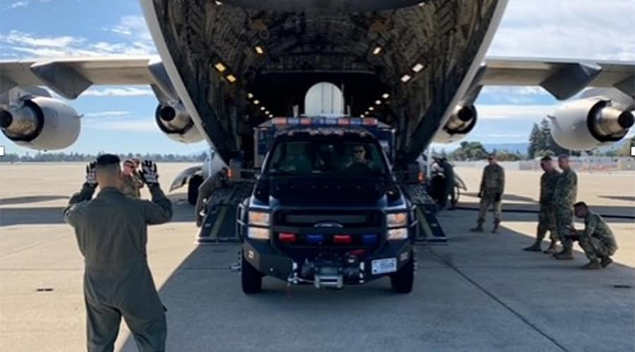 military truck in the belly of an aircraft while on the ground